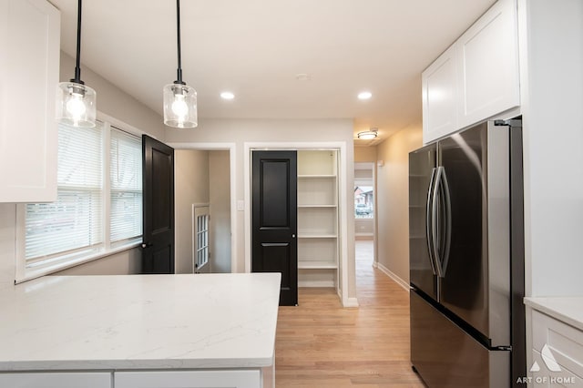 kitchen with white cabinets, light wood-style floors, recessed lighting, and freestanding refrigerator