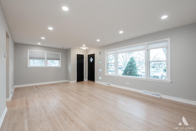 unfurnished living room featuring visible vents, recessed lighting, and plenty of natural light