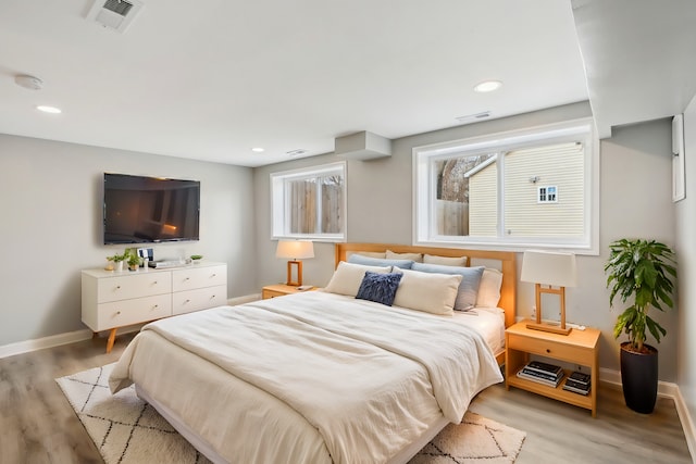 bedroom with baseboards, visible vents, and light wood-type flooring