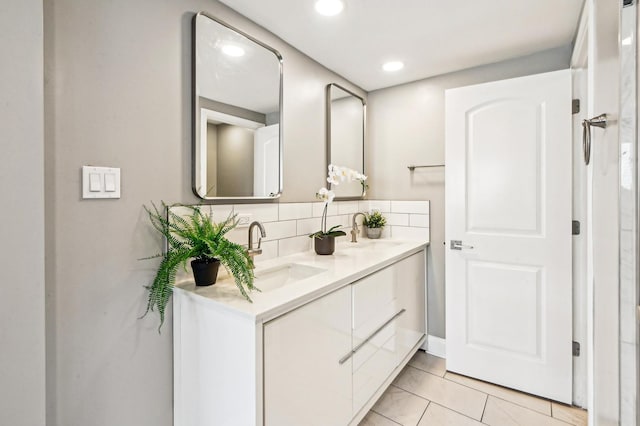 full bath featuring double vanity, recessed lighting, decorative backsplash, and a sink