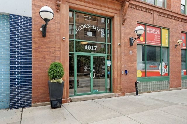 doorway to property featuring brick siding