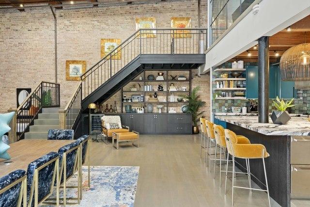bar with stairs, a high ceiling, wood finished floors, and brick wall