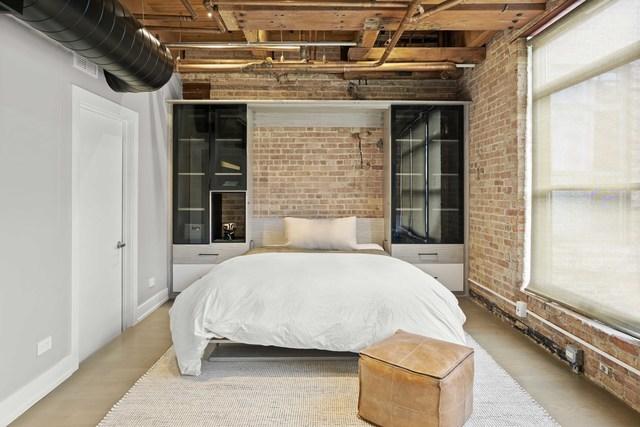 bedroom with baseboards and brick wall