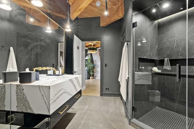 bathroom featuring marble finish floor, vanity, beamed ceiling, and a shower stall