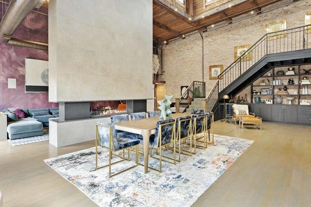 dining area with a high ceiling, stairway, brick wall, and wood finished floors