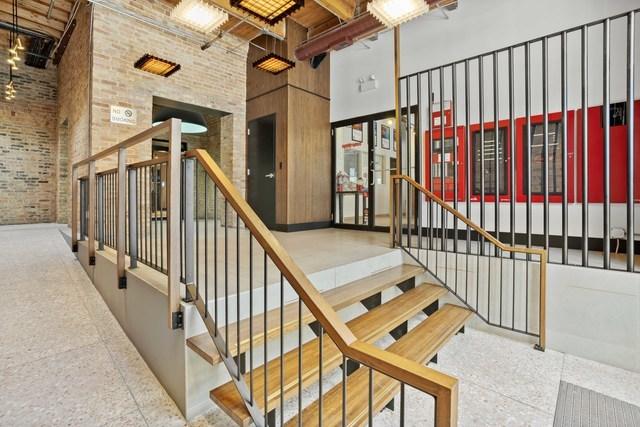 stairway featuring a high ceiling and brick wall