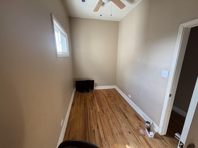 empty room featuring baseboards, wood finished floors, and ceiling fan