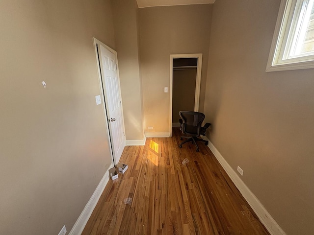 hall featuring baseboards and wood finished floors