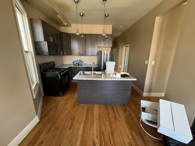 kitchen with baseboards, freestanding refrigerator, dark wood-type flooring, and gas stove