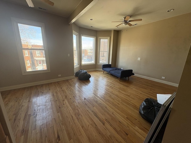 interior space featuring a ceiling fan, wood finished floors, a healthy amount of sunlight, and visible vents