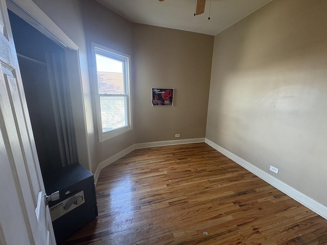 empty room with a ceiling fan, baseboards, and wood finished floors