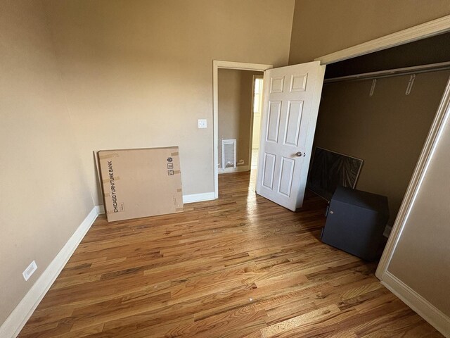 unfurnished bedroom with baseboards, visible vents, and wood finished floors