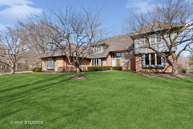 english style home with a front lawn and brick siding