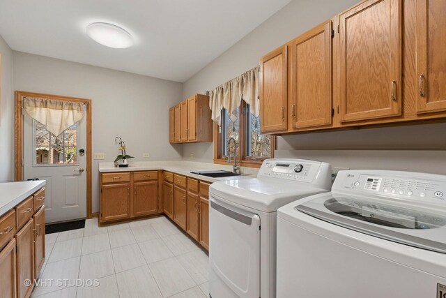 laundry room with washer and dryer, cabinet space, a sink, and plenty of natural light