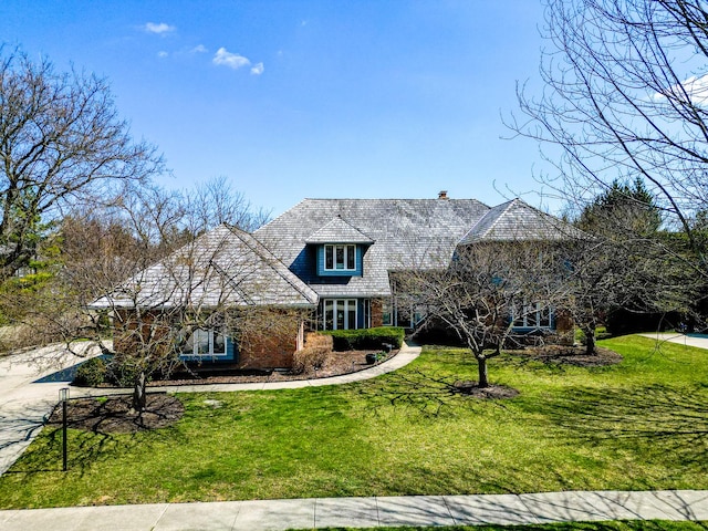 view of front facade featuring brick siding and a front yard