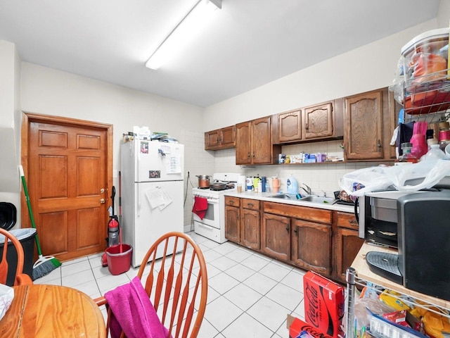 2124 W 24th St, Chicago, IL 60608 - kitchen featuring light countertops, tasteful backsplash, white appliances, light tile patterned floors, and a sink