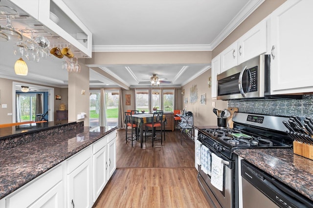 472 Lakewood Blvd, Park Forest, IL 60466 - kitchen with light wood-style floors, a healthy amount of sunlight, appliances with stainless steel finishes, white cabinetry, and ornamental molding