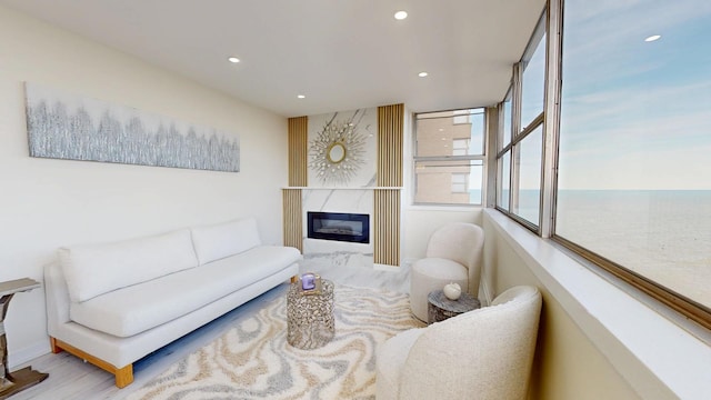 living room with a water view, a fireplace, and recessed lighting