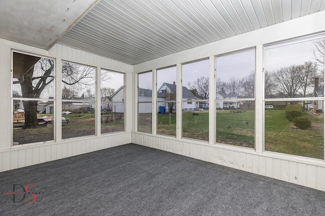 unfurnished sunroom with a residential view and a healthy amount of sunlight