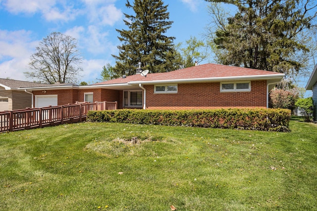 exterior space with a lawn, a garage, and brick siding