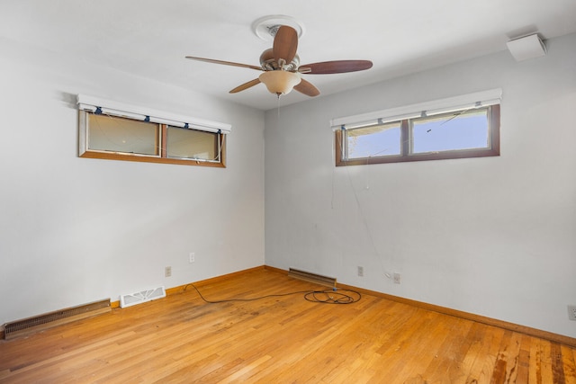 spare room featuring baseboards, visible vents, wood finished floors, and ceiling fan