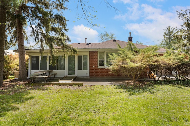 back of property with a sunroom and a lawn