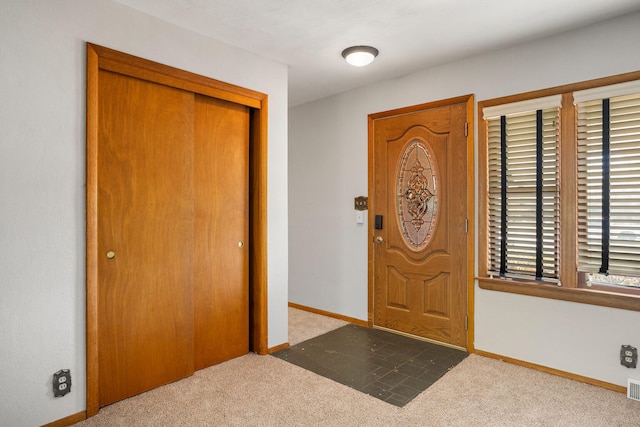 carpeted foyer entrance with baseboards and visible vents
