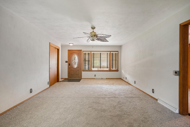 spare room with ceiling fan, visible vents, light carpet, baseboards, and baseboard heating