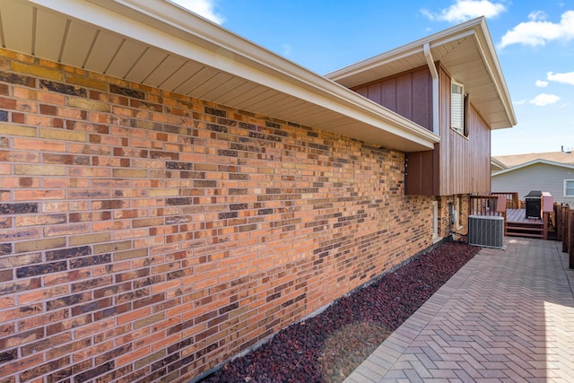 8900 W 169th Pl, Orland Hills, IL 60487 - view of side of property with board and batten siding, brick siding, central AC unit, and a patio