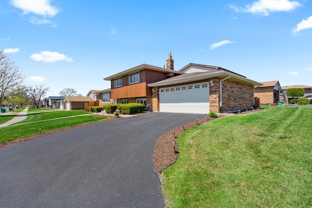 8900 W 169th Pl, Orland Hills, IL 60487 - tri-level home featuring a front yard, a garage, brick siding, and driveway