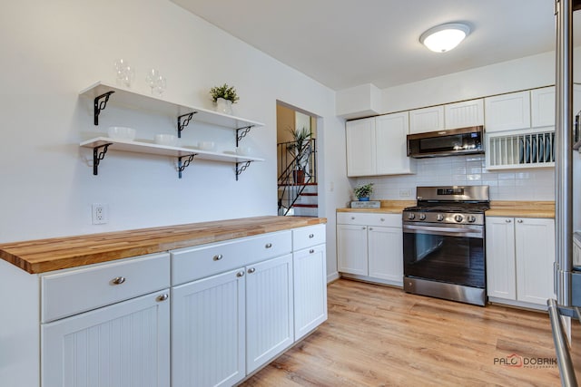 kitchen featuring decorative backsplash, light wood finished floors, wood counters, appliances with stainless steel finishes, and open shelves