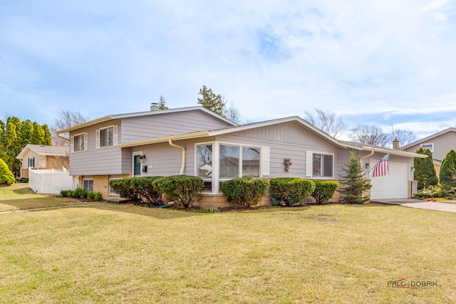split level home featuring a front yard, driveway, and an attached garage
