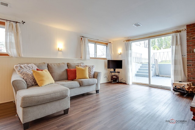 living area featuring visible vents and wood finished floors