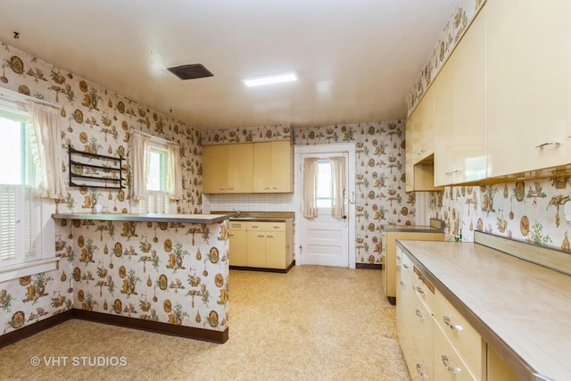 940 W Main St, Saint Charles, IL 60174 - kitchen featuring wallpapered walls, healthy amount of natural light, cream cabinetry, and baseboards