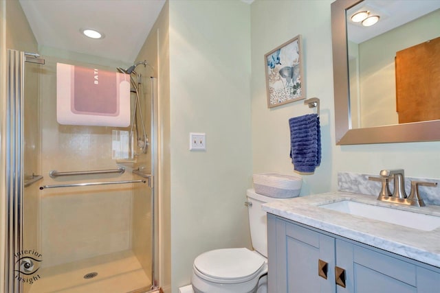 bathroom featuring toilet, a stall shower, and vanity