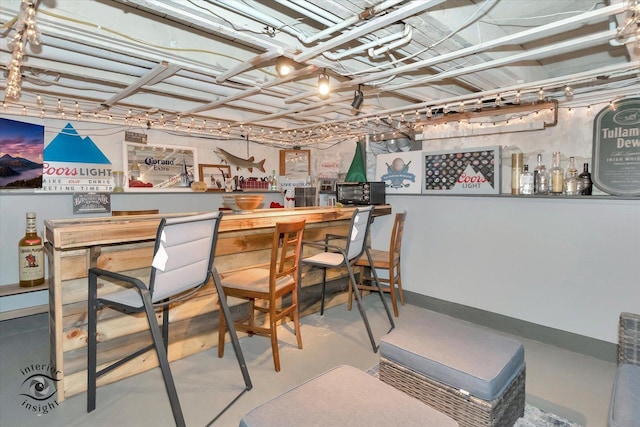 bar featuring a bar and finished concrete floors