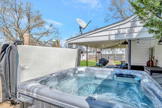 exterior space featuring grilling area, fence, and a hot tub