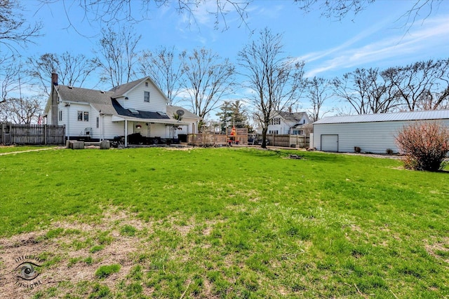view of yard with a garage, an outdoor structure, and fence