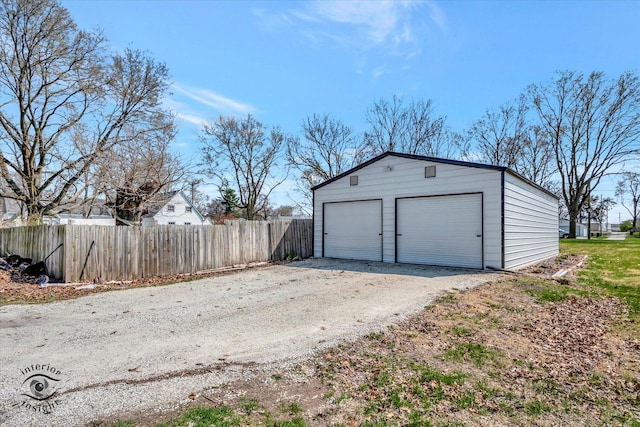 detached garage featuring fence