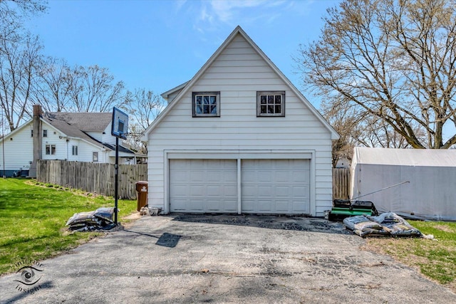 garage featuring a detached garage and fence