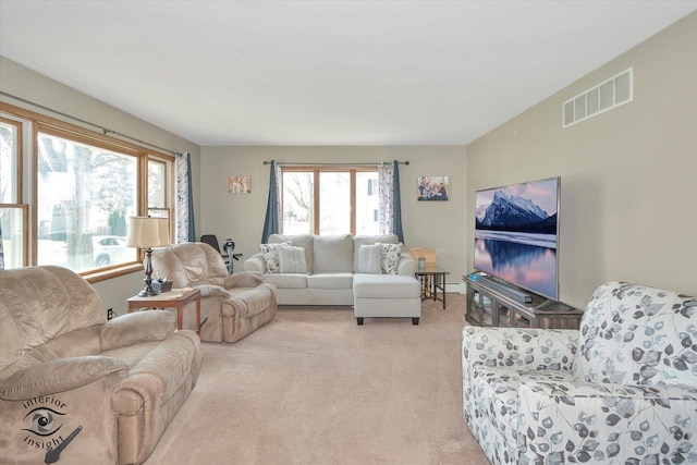 living area featuring visible vents and light carpet