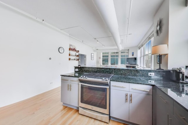 161 W Harrison St Unit 601, Chicago, IL 60605 - kitchen featuring gas range, light wood-type flooring, and dark stone countertops