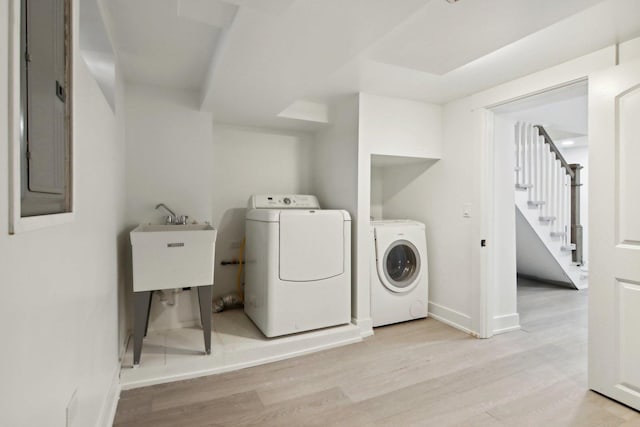 6734 N Hamlin Ave, Lincolnwood, IL 60712 - clothes washing area with light wood finished floors, washing machine and clothes dryer, baseboards, and electric panel