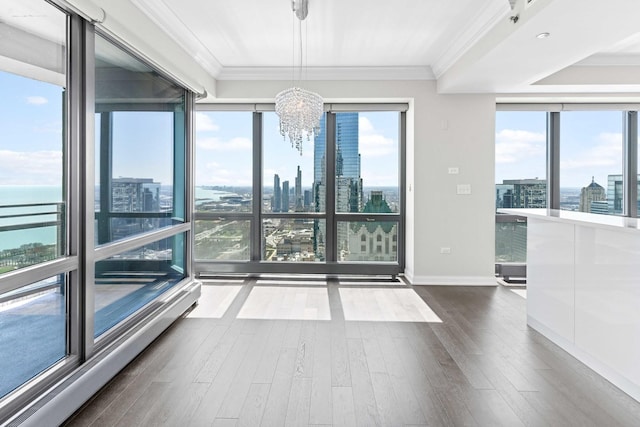 unfurnished room featuring a view of city, plenty of natural light, an inviting chandelier, and crown molding