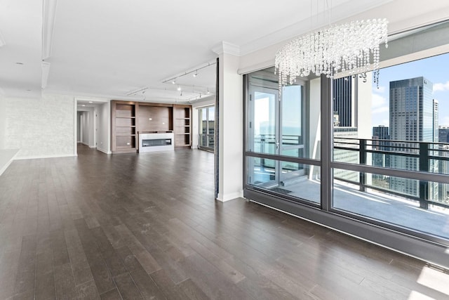 interior space featuring crown molding, a notable chandelier, and dark wood-style floors