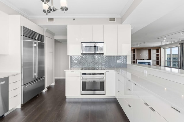 kitchen featuring modern cabinets, visible vents, appliances with stainless steel finishes, light countertops, and dark wood-style floors