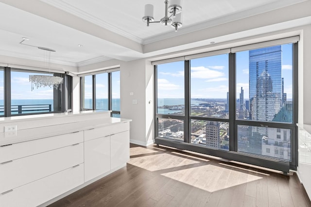 bathroom featuring baseboards, a notable chandelier, hardwood / wood-style flooring, and ornamental molding