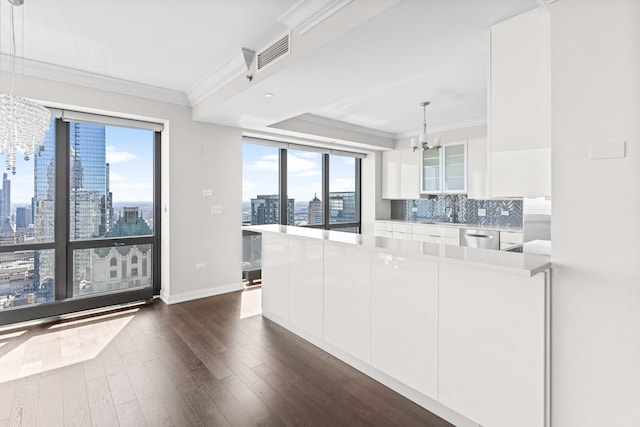 kitchen with a chandelier, white cabinetry, dark wood-type flooring, stainless steel dishwasher, and a city view