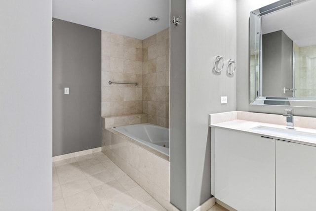 bathroom featuring tiled shower / bath, tile patterned floors, vanity, and baseboards