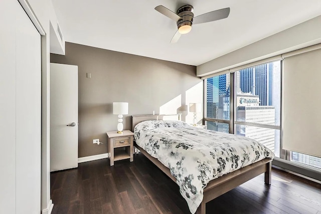 bedroom with dark wood-type flooring, baseboards, and ceiling fan